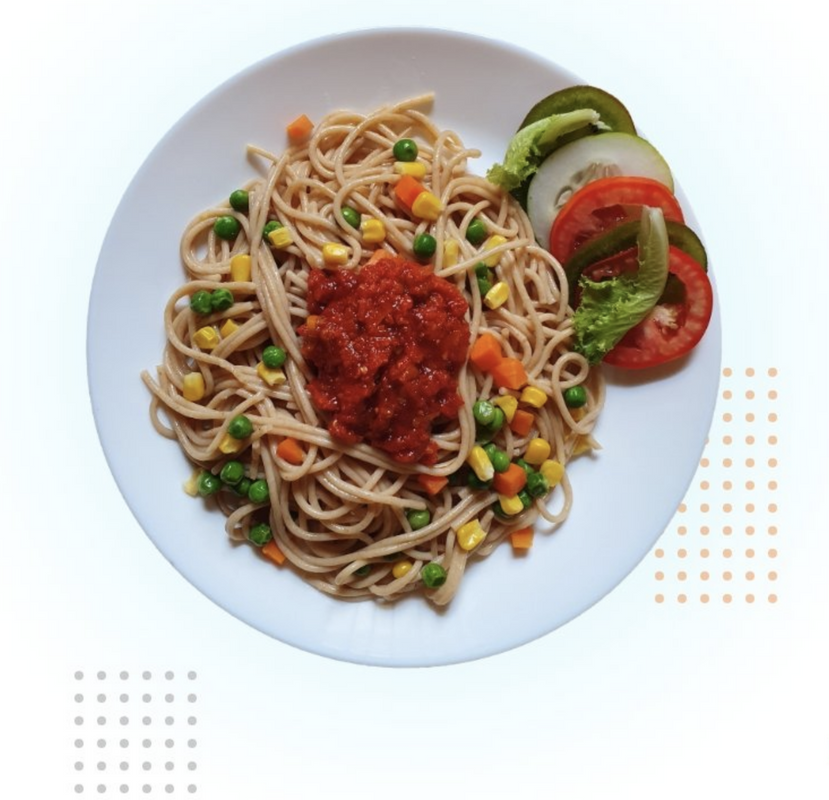 Plato de pasta con salsa y vegetales